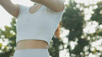 Young woman stretching before running while looking for beautiful landscape on roadside. Sports and Recreation video