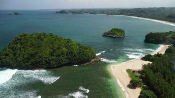 The beautiful curve of the coastline is close to a small island and the crashing of big waves video