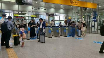 Osaka, japan på september 29, 2023. tåg passagerare på skenben osaka station godkänd genom de biljett Port. flera människor var sett i en rusa till styrelse de shinkansen kula tåg eller jr tåg video