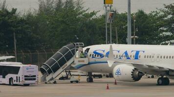 phuket, Tailandia febrero 25, 2023 - avión boeing 737 de largarse aerolíneas a phuket aeropuerto. escalera unión cósmica con el aeronave. delantal autobús esperando para pasajeros aviación industria concepto video