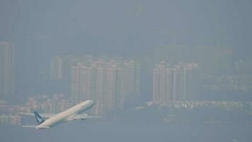 HONG KONG NOVEMBER 09, 2019 - Boeing 777 of Cathay Pacific taking off and climbing at Hong Kong airport. Passenger flight departure, side view video