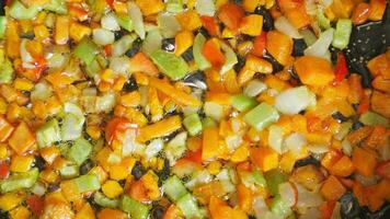 Frying fresh vegetables in frying pan, carrots, onions, peppers, paprika. video