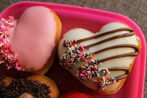 enamorado rosquillas puesto fuera en un rosado plato foto