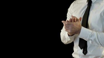 Man folds his palms isolated against black background video