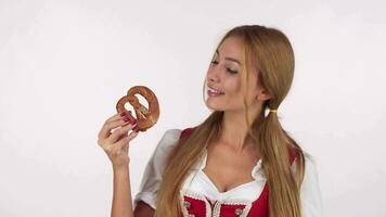 Bavarian woman licking her lips, looking at delicious pretzel video