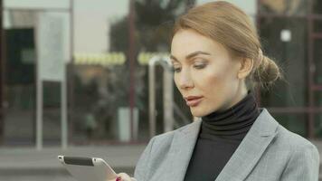 Attractive businesswoman using digital tablet outdoors video