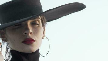 Gorgeous red lipped woman wearing black hat looking away thoughtfully video