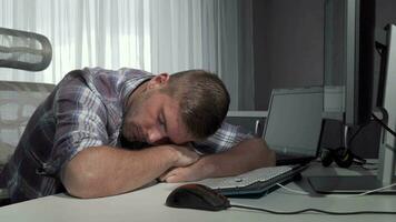 Man sleeping on his desk after finishing working on the computer video