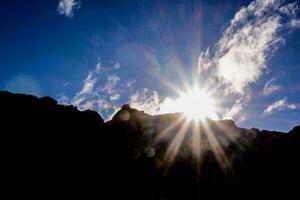 the sun shines brightly over a mountain range photo