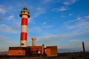 a lighthouse with a red and white striped tower photo