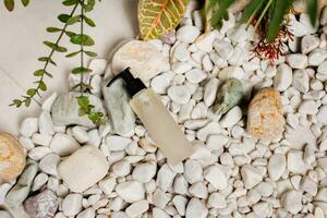 Mockup of a plastic tube against the white pebbles stone texture and background. An environmentally friendly product, natural components. Cosmetic beauty product branding mockup photo