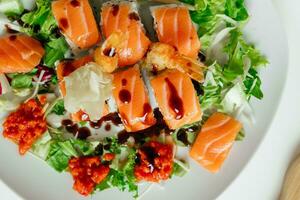 Top view of Japanese sushi. Rolls with tuna, salmon, shrimp, crab and avocado. Top view of rainbow uramaki, hosomaki and nigiri with teriyaki sauce photo