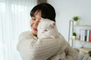 Happy Woman Playing with Cat in Cozy Living Room at Home. photo