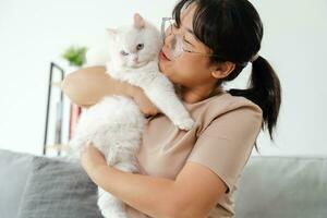 Happy Woman Playing with Cat in Cozy Living Room at Home. photo