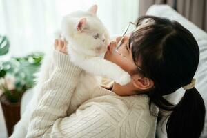 contento mujer jugando con gato en acogedor vivo habitación a hogar. foto