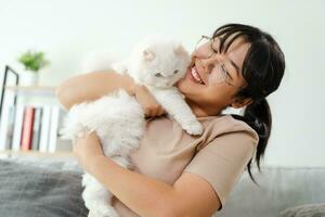 Happy Woman Playing with Cat in Cozy Living Room at Home. photo