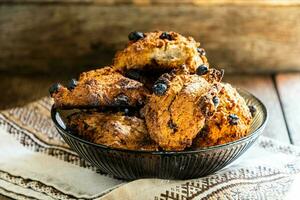 Homemade oatmeal cookies in a glass brown bowl on a kitchen napkin on a wooden table. photo