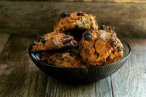 Homemade oatmeal cookies in a glass brown bowl on a kitchen napkin on a wooden table. photo