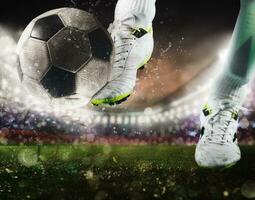 Football scene with close up of a soccer shoe hitting the ball with power photo