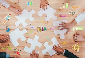 Businessmen working together to build a puzzle as teamwork, partnership and integration concept photo