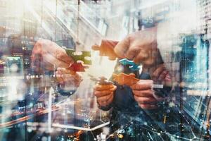 Businessmen working together to build a puzzle as teamwork, partnership and integration concept photo