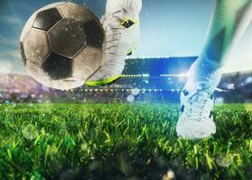 Football scene with close up of a soccer shoe hitting the ball with power photo