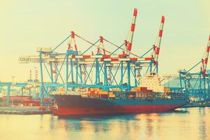 Merchant ship moored at the port with the containers ready for shipping photo