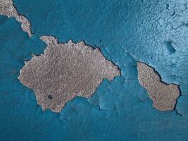 Blue paint on old concrete wall with cracks as background texture photo
