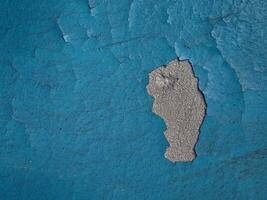 Blue paint on old concrete wall with cracks as background texture photo