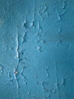 Blue paint on old concrete wall with cracks as background texture photo