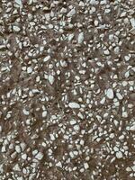 Rough cement wall with small pebbles as background texture photo