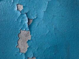 Blue paint on old concrete wall with cracks as background texture photo