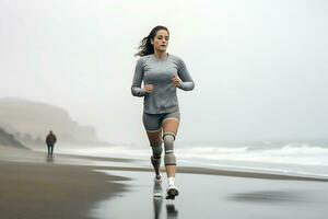 A young disabled woman in a gray tracksuit is jogging along the seashore in cloudy weather. AI Generative photo