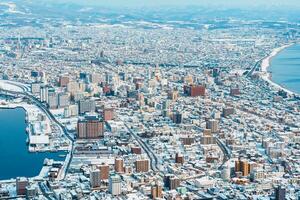 hermosa paisaje y paisaje urbano desde hakodate montaña con nieve en invierno estación. punto de referencia y popular para atracciones en Hokkaidō, japon.viajes y vacaciones concepto foto