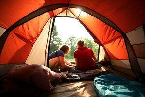 Two women sit near a tourist tent and enjoy the view of nature in sunny weather. View from the back, inside the tent. AI Generative photo