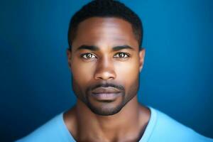 A young African American man in a blue t-shirt poses against a dark blue background. man looking at camera. AI Generative photo