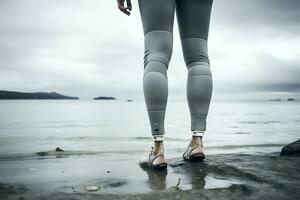 Prostheses on the legs of a young disabled woman. Woman posing against the backdrop of the sea in cloudy weather. Legs close up. AI Generative photo