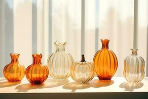 AI Generative. Several transparent glass vases in the form of an orange and white pumpkin stand on a windowsill illuminated by the sun's rays. Horizontal photo