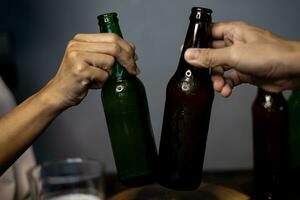 Two Friends Toasting With Bottle Of Light Beer. photo