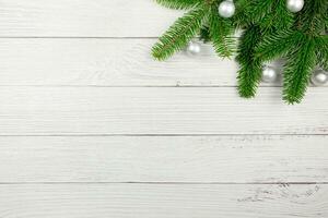 Christmas flat lay background with fir tree branches and silver balls decorations on white wooden background. Top view. Copy space. photo