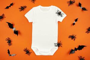 Halloween white baby girl or boy bodysuit mockup flat lay with spiders and bats on orange background. Design onesie template, print presentation mock up. Top view. photo