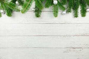 Christmas flat lay background with fir tree branches and silver balls decorations on white wooden background. Top view. Copy space. photo