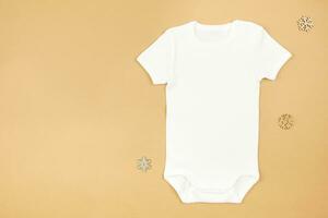 Christmas white baby girl or boy bodysuit mockup flat lay with snowflakes decoration on paper background. Design onesie template, print presentation mock up. Top view. photo