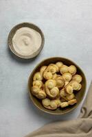 Puff pastry eyelet, Palmier cookies in a bowl with cinnamon and sugar on the light concrete background. Top view. photo