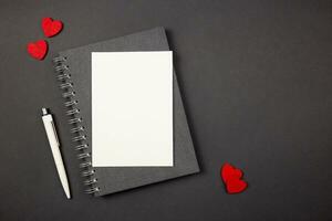 Greeting card mockup with red hearts on dark background. Valentines, mothers, womens day, anniversary and birthday greeting flat lay. Top view. Copy space. photo