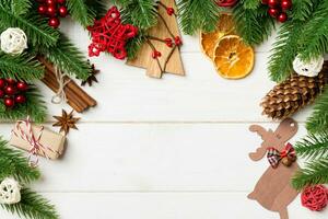 Top view of fir tree branches and festive decorative toys on wooden background. New Year time concept with empty space for your design photo