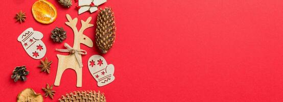 Top view Banner of red background decorated with festive toys and Christmas symbols reindeers and New Year trees. Holiday concept with copy space photo