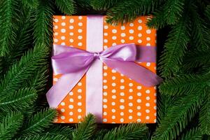 Top view of festive gift box decorated with green fir tree branches. Christmas time with copy space photo