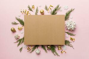 Flat lay Christmas composition. square Paper blank, pine tree branches, christmas decorations on Colored background. Top view, copy space for text photo