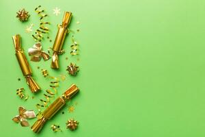 Christmas crackers with shiny confetti on color background, top view, copy space photo